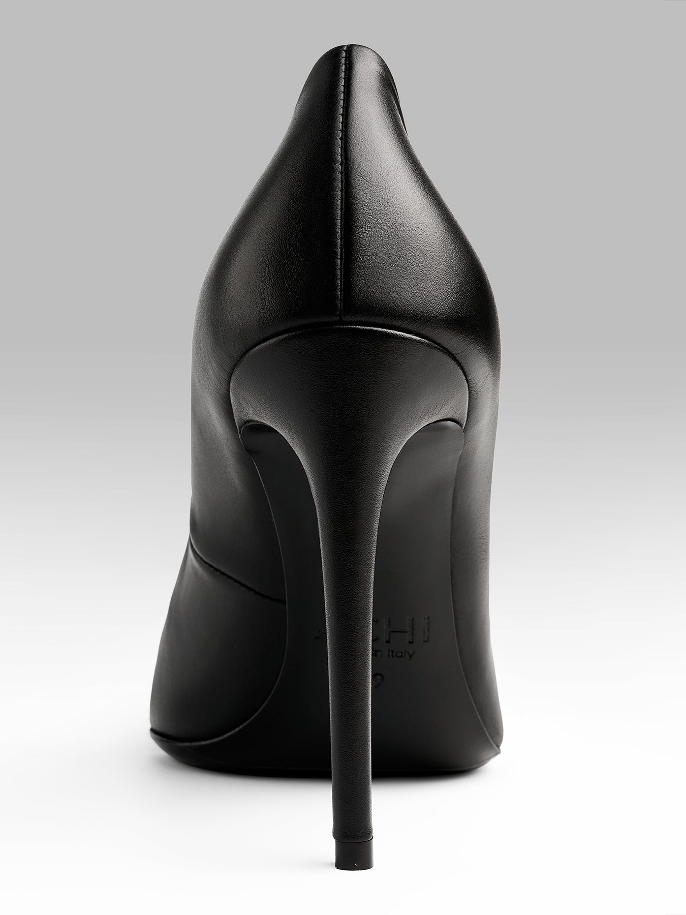 Black high-heeled shoe on a light gray background